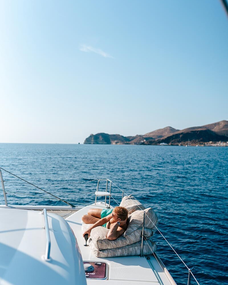 Guy sunbathing on a catamaran deck