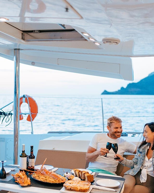 Couple enjoying a meal on a Catamaran in Santorini